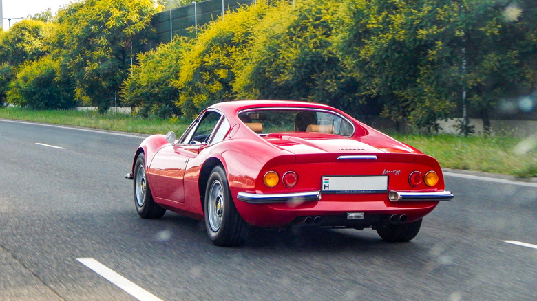 Rear view of a red Ferrari 246 Dino being driven on the road