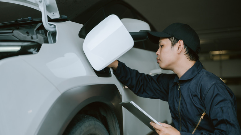 A mechanic inspecting an electric vehicle.