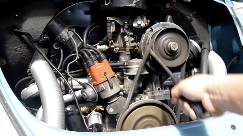 Replacing an accessory belt on an air-cooled engine with the belt and a screwdriver.