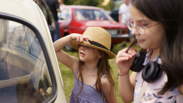 Young children looking at a vehicle at a car show