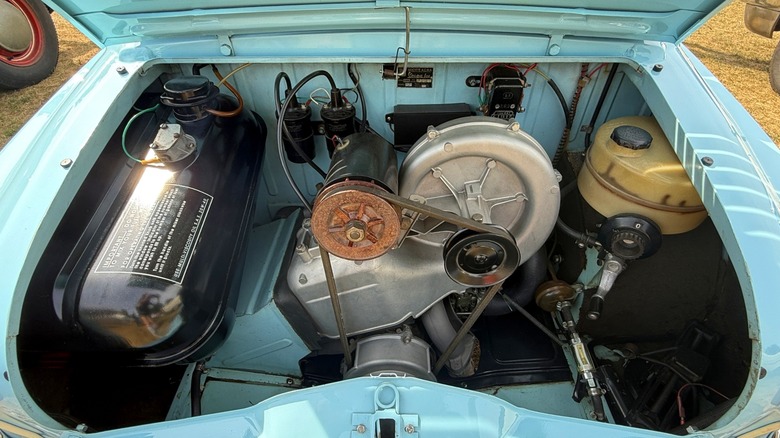 The two-stroke two-cylinder 394 cc engine of the 1960 Vespa 400 displayed through the open trunk.