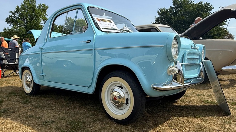 A blue, 1960 Vespa 400 microcar on display at a local car show.