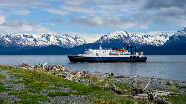 Image of MV Tustumena against a backdrop of snow-covered mountains.