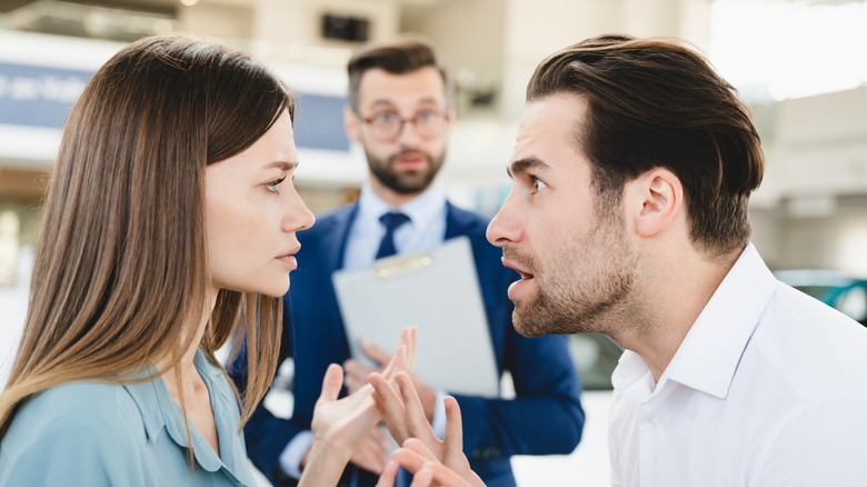 A couple fights while buying a car