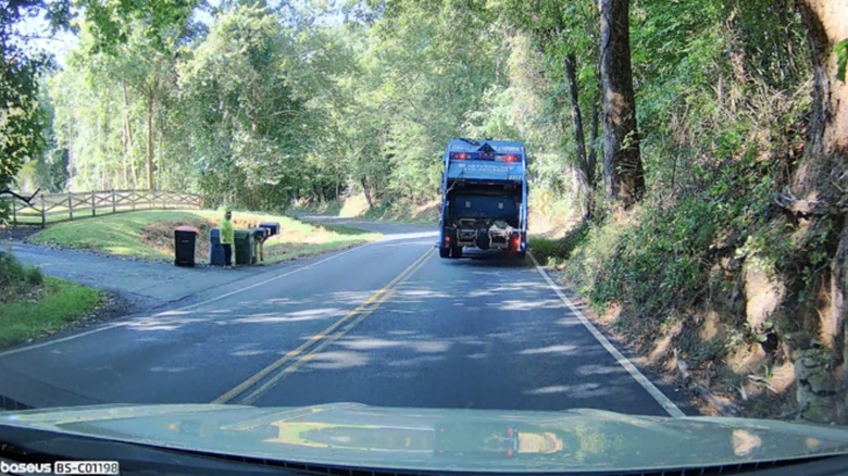 Baseus dashcam footage of trash truck on road in daylight