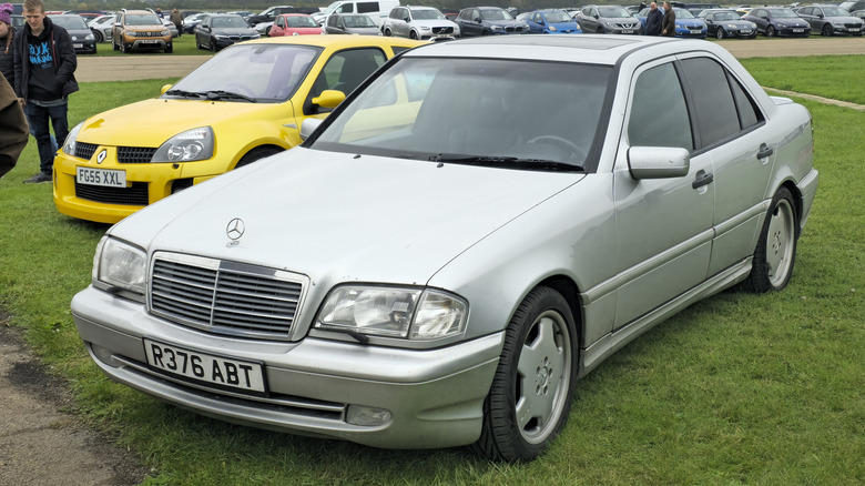 A silver Mercedes-Benz C43 AMG sits parked on a lawn.
