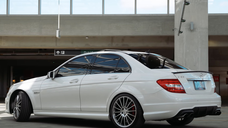 A white Mercedes-Benz C63 AMG sits parked.