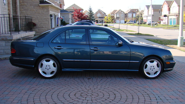 A dark Mercedes-Benz E55 AMG sits in a driveway.