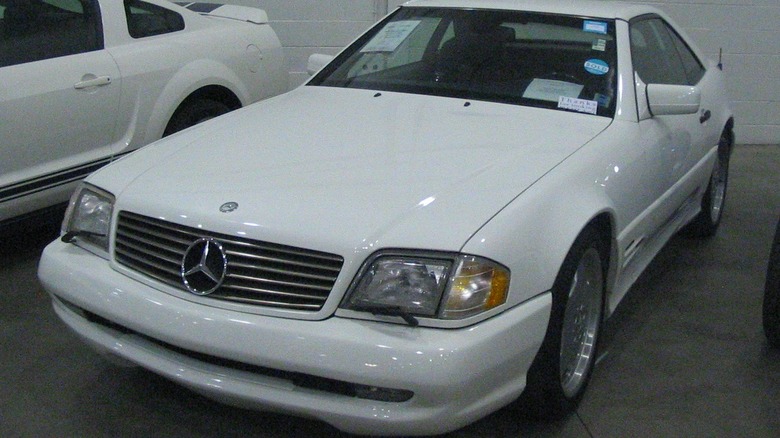 A white Mercedes-Benz SL500 sits parked in a garage.