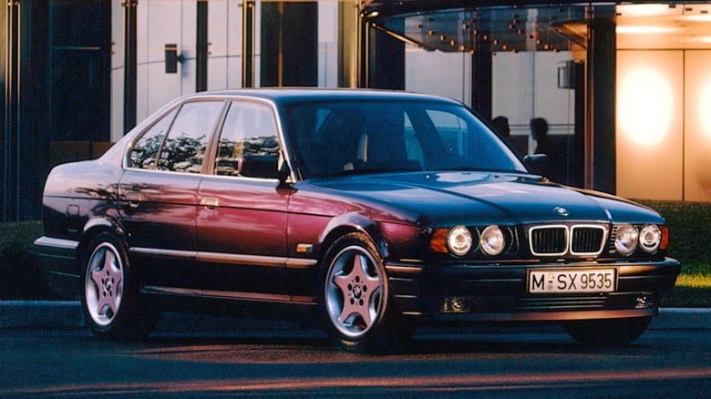 An E34-generation BMW 525i sedan sitting in beautiful sunset lighting.