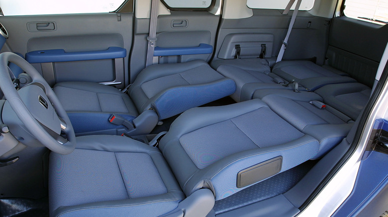 The interior of a 2003 Honda Element with all of its seats folded down.