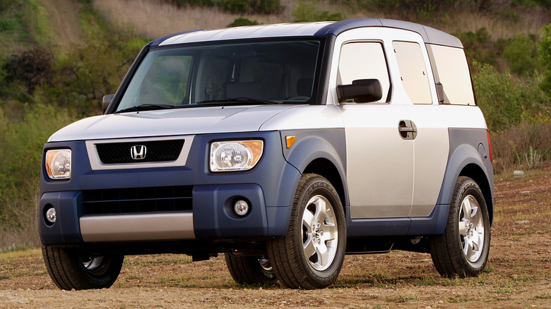 A 2003 Honda Element stationary on dirt.