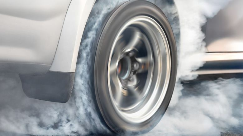 A close-up of a car's tire doing a burn-out.