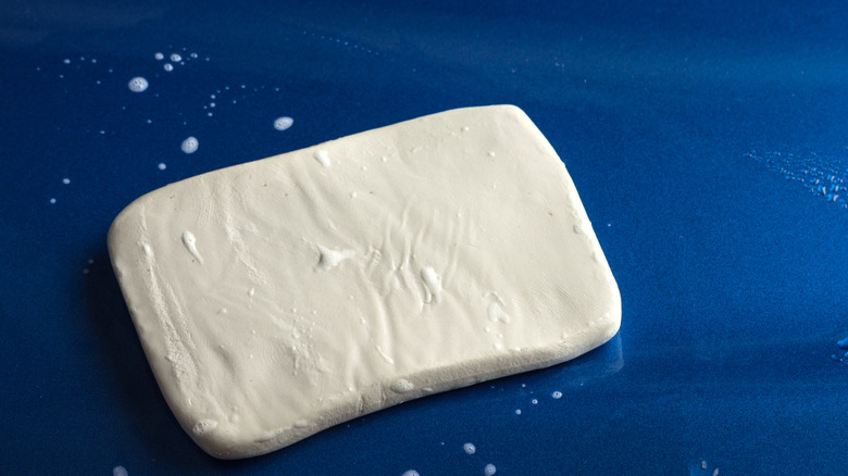 A white clay bar on a car's surface