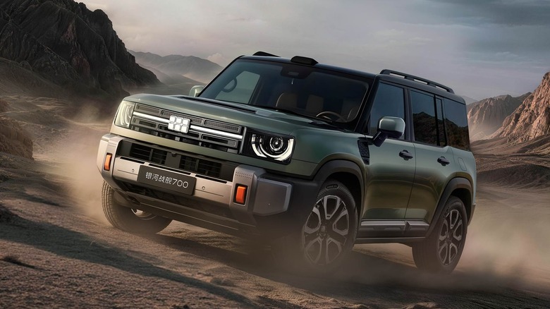 Front 3/4 of a green Geely Battleship 700 SUV driving on a dirt road
