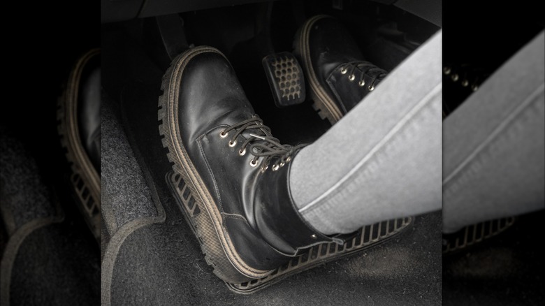 A person engaging the clutch pedal with the left foot while operating the accelerator with the right.