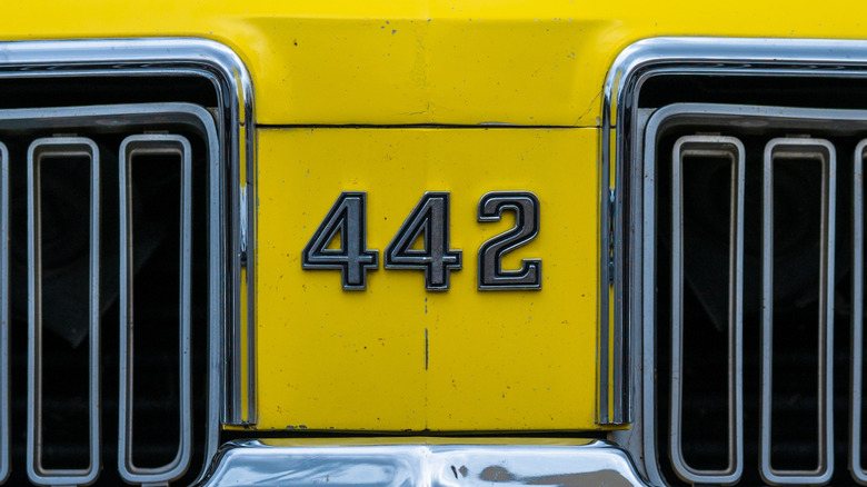 A closeup of the 442 badge on the front of a yellow Oldsmobile 4-4-2