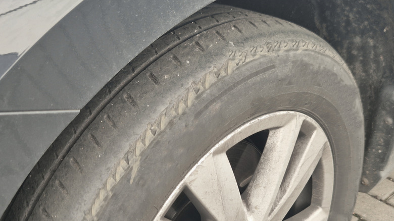 A closeup of a tire with excessive tread wear on the outside, disproportionate to the rest of the tire