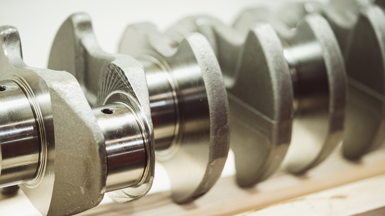 A closeup of a cast crankshaft with a white background