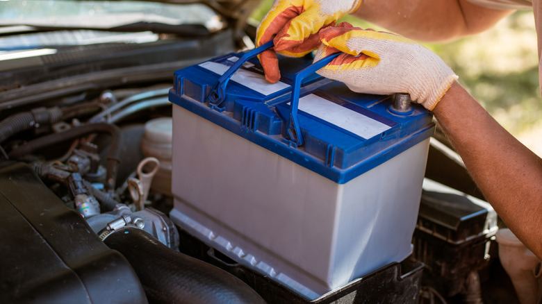 A man removing a car battery.