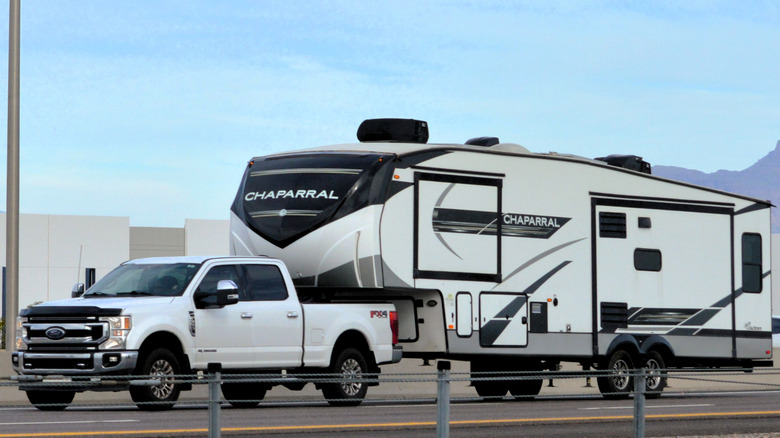 Fifth-wheel RV towed by a pickup truck.