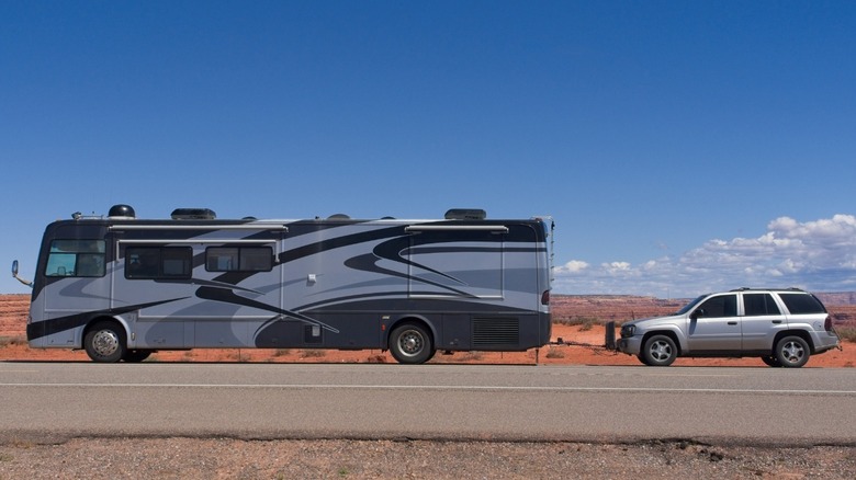 Large Class A RV towing an SUV.
