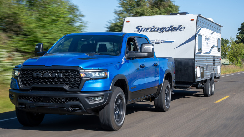A blue Ram 1500 pickup truck towing a trailer