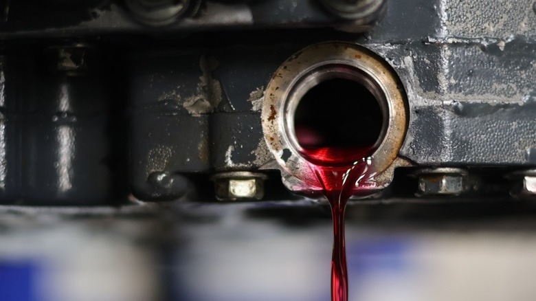 Bright red transmission fluid draining from a car's gearbox