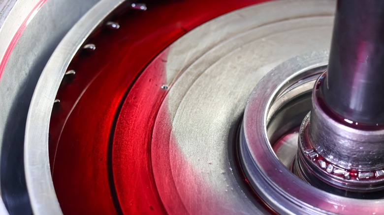 An internal transmission component submerged in red ATF