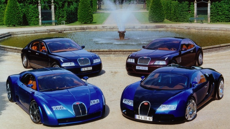 Bugatti concept cars (EB 118, EB 218, EB 18/3 Chiron, and EB 18/4 Veyron) parked near a fountain.