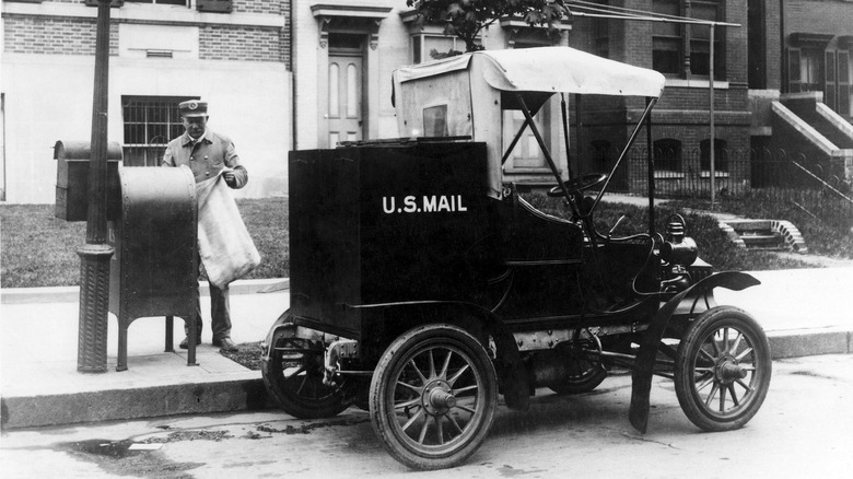 A Columbian Mark 3 postal vehicle with a mail carrier delivering letters.