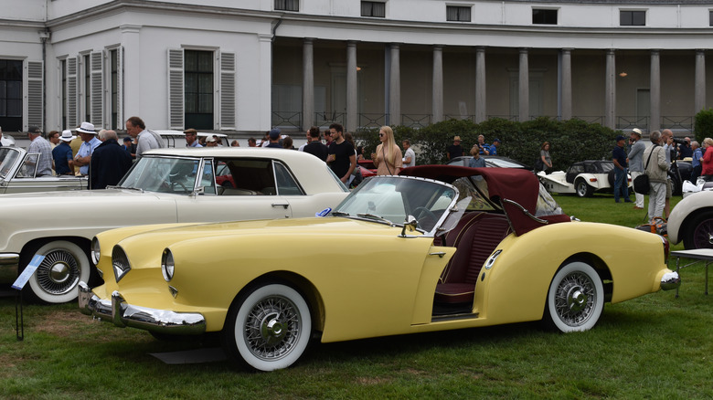A classic Kaiser Darrin in yellow on display at a car show