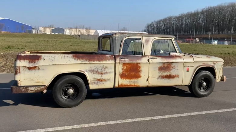 A right-hand-side profile of a rusty white 1963 Dodge D-200 crew cab