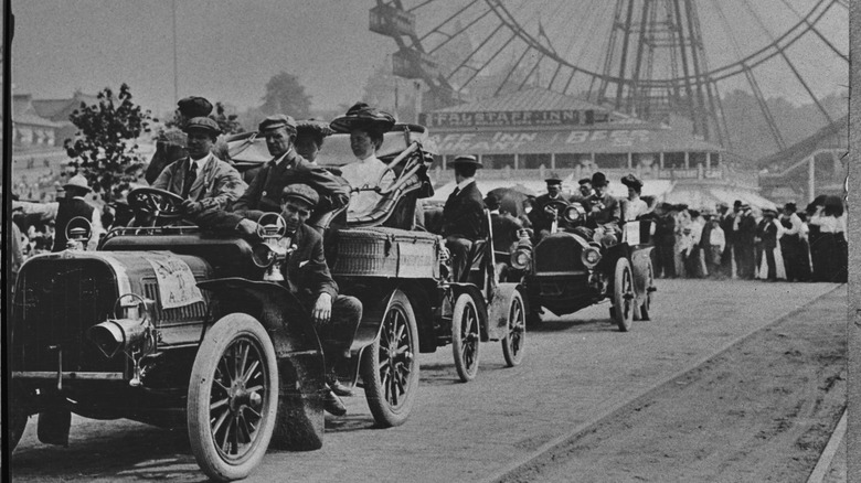 A black and white image of early automobiles and drivers on parade