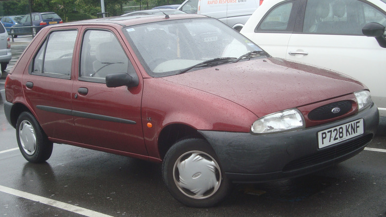 A maroon 1996 Ford Fiesta in a parking lot.