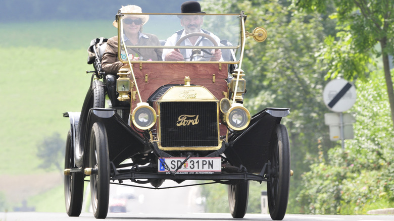 Couple driving a Ford Model T in period-correct clothing