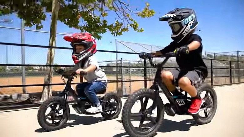 Two children ride StaCyc electric bicycles.