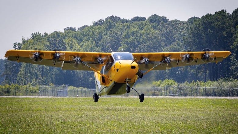 An Electra hybrid-electric aircraft taking off on a field of grass