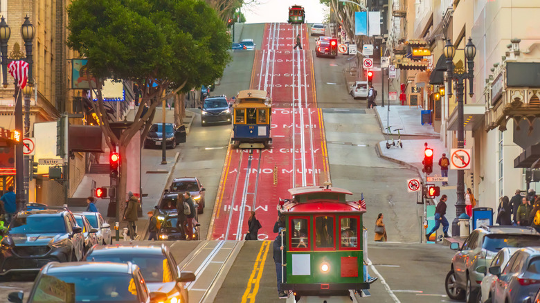 Trolleys and cars travel down a San Francisco street