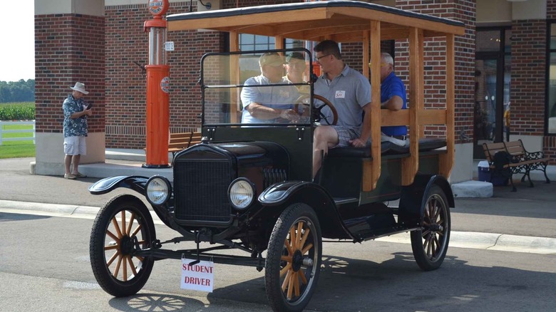 A driving instructor teaching students how to drive a Ford Model T