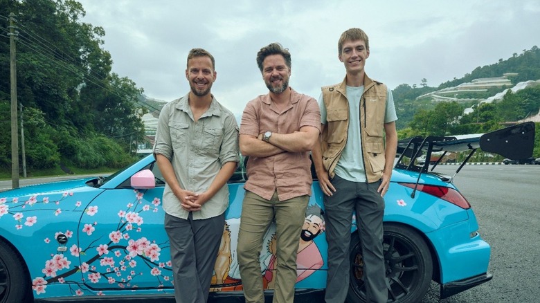 The new hosts of the "The Grand Tour" leaning against a Nissan Z painted with a cherry-blossom design