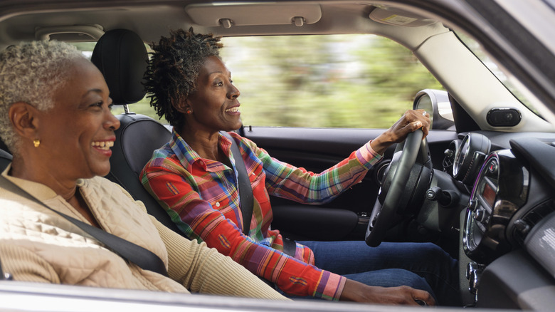 A senior driver, with passenger, enjoys a drive