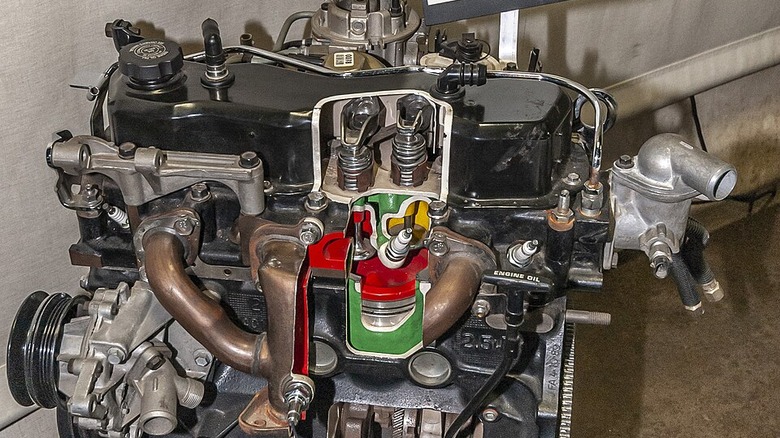 A 1990 GM Iron Duke engine with parts cut away to reveal the inner arrangement.