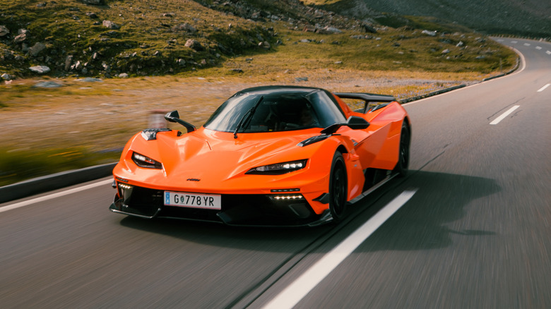 An orange KTM X-Bow GT-XR driving on a mountain road
