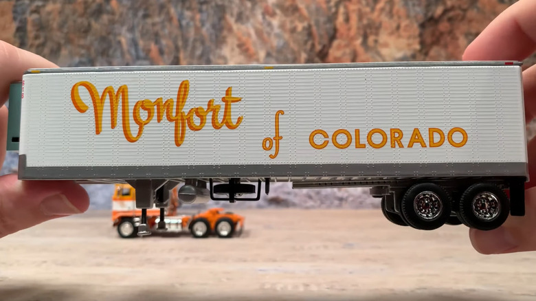 A scale replica of a Monfort truck cab being held in the air