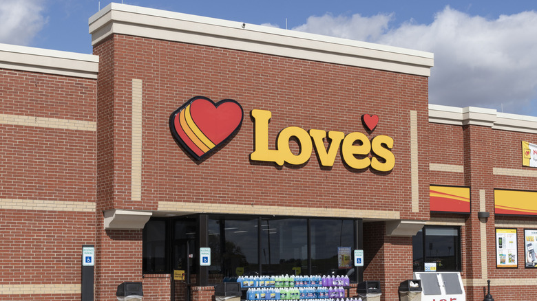 A Love's gas station storefront against a blue sky with clouds