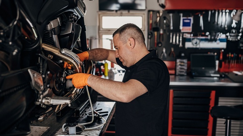Mechanic performing motorcycle maintenance