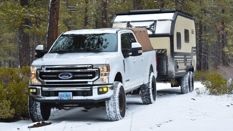 Ford pickup truck with a trailer on a snow-covered track