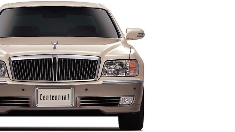 A cropped picture looking directly at the front of a beige-painted 1999 Hyundai Centennial sedan.