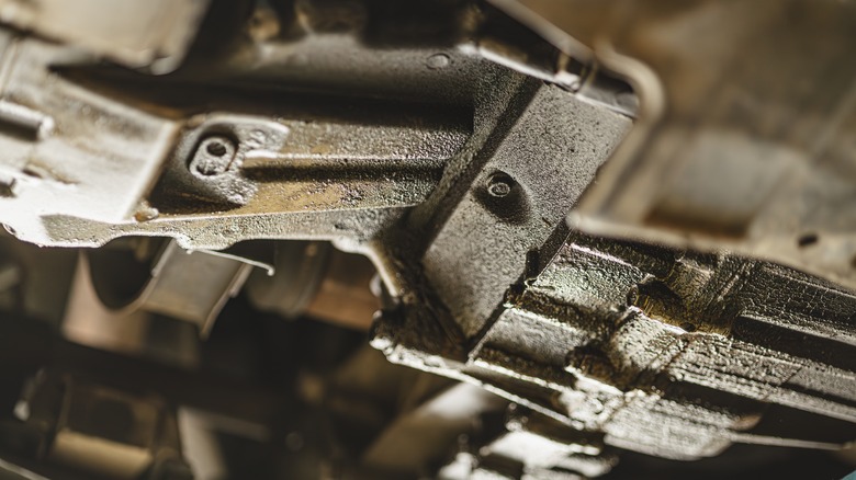 Visible oil leak and oil stain under a car engine